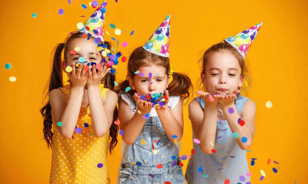 Happy birthday little girls with confetti on yellow background.
