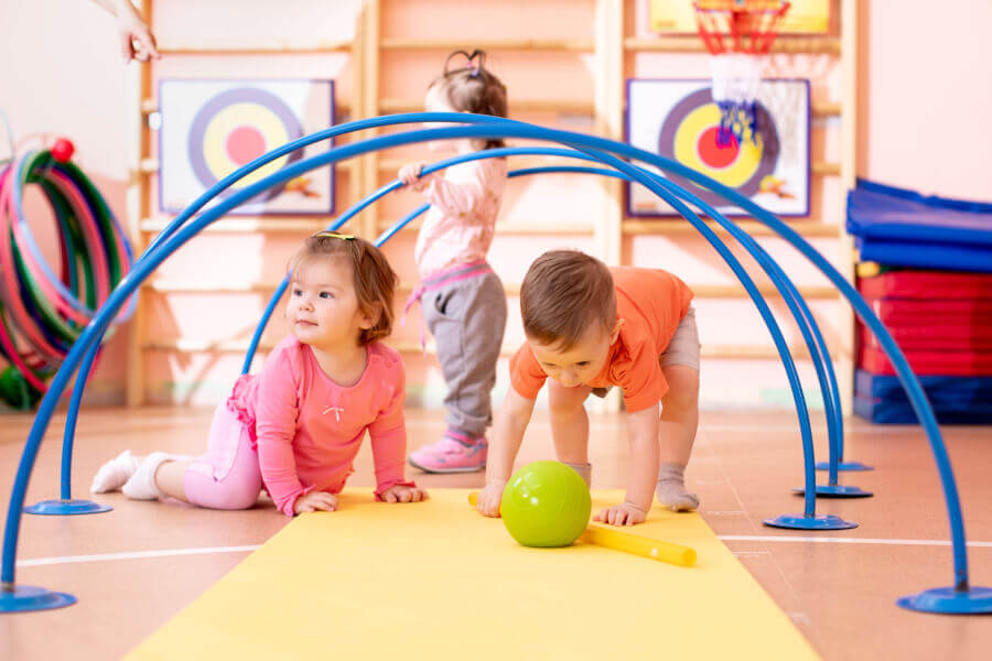 Nursery babies playing together in a kids gym.