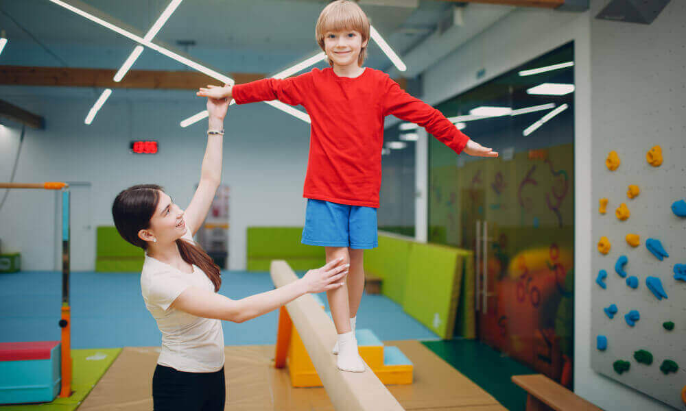 Six-year old girl swinging from the gym bar.